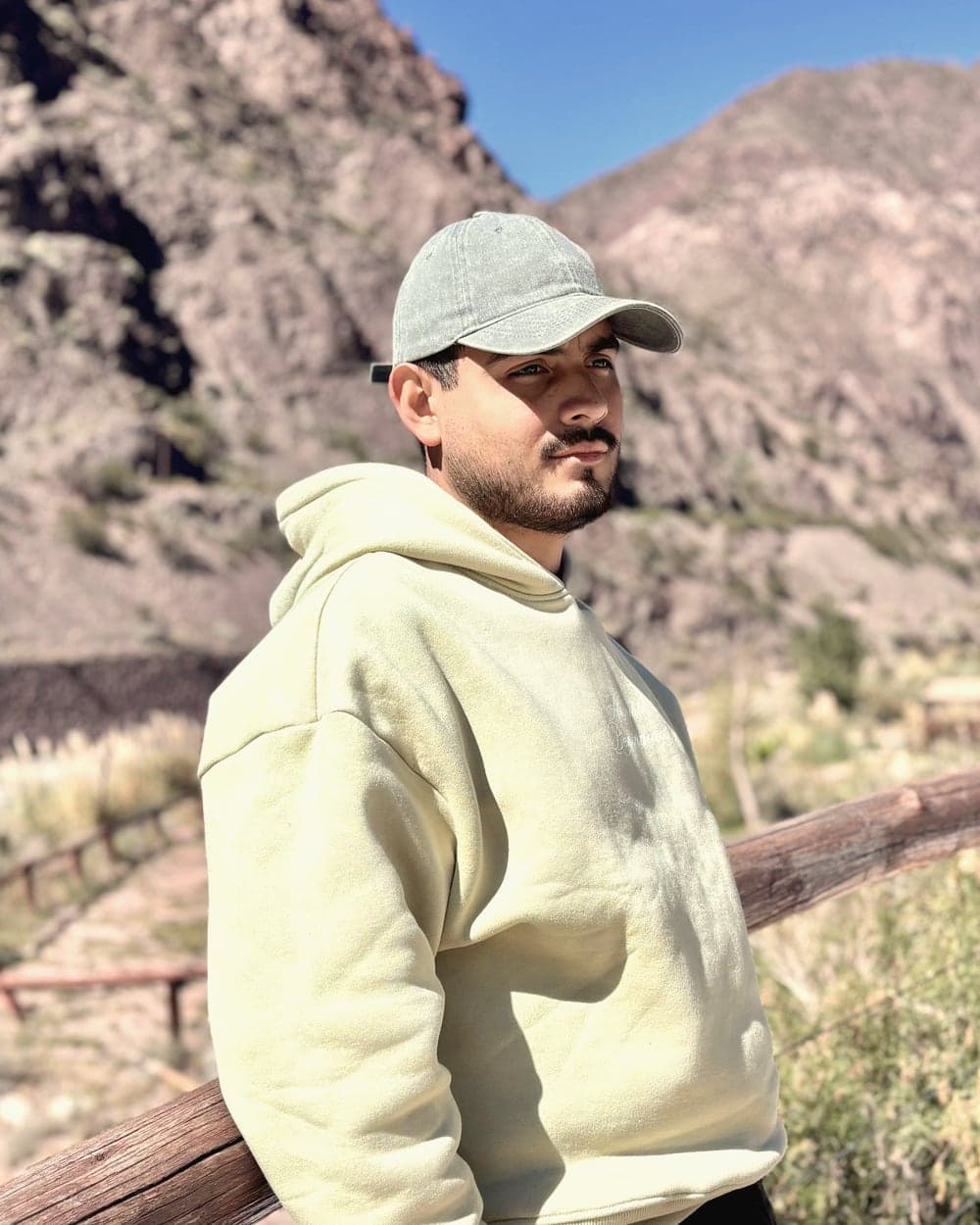 Fabio Escudero apoyado en una baranda de madera, con las montañas de Mendoza de fondo